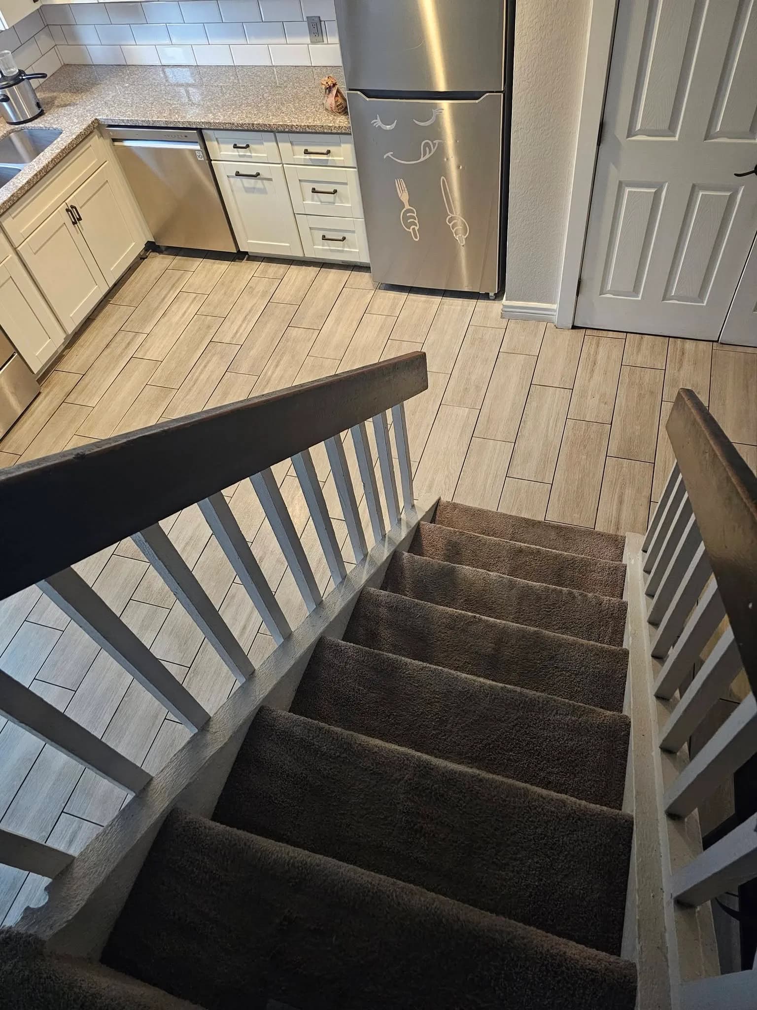 Vacuumed carpeted stairs above a clean kitchen after a New Star empty-home cleaning