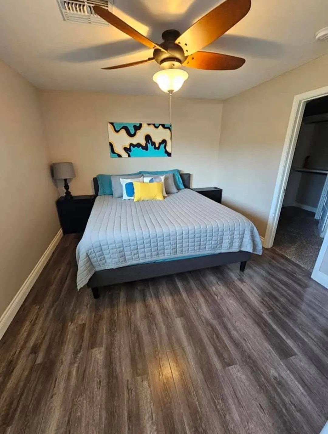 Clean bedroom with made bed and wood-look floors from a New Star appointment