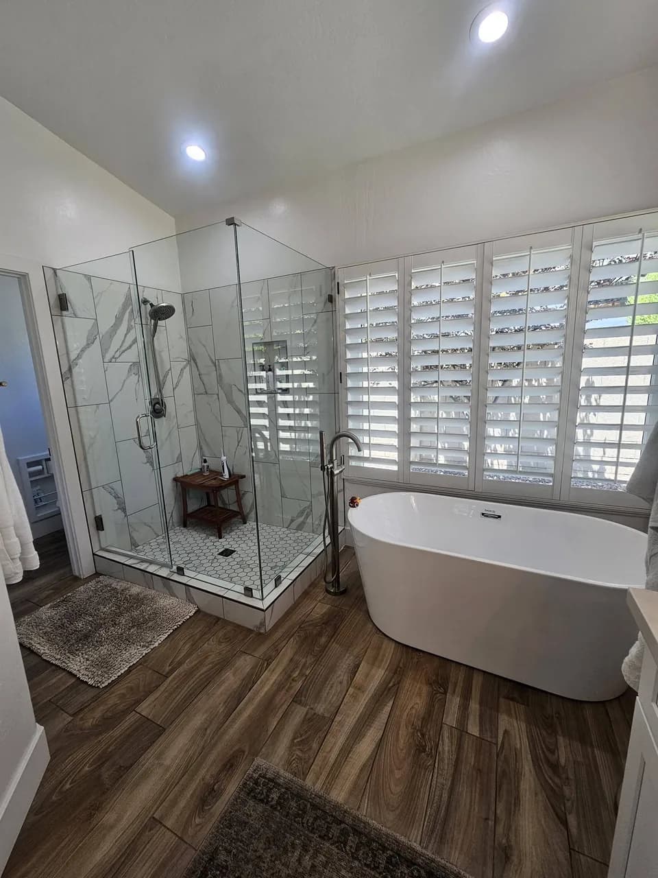 Clean bathroom with shower, tub, vanity, and tile floor from New Star Cleaning work